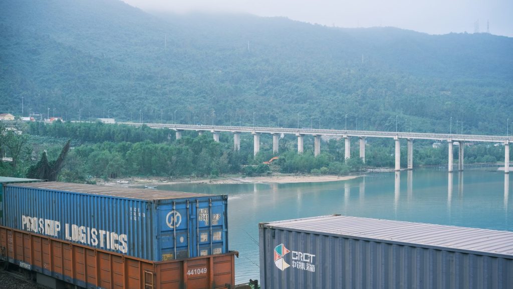 A train traveling down tracks next to a body of water