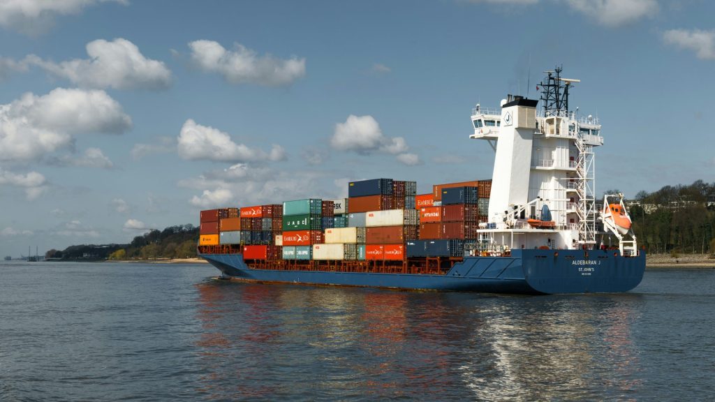 A cargo ship sails across a body of water.